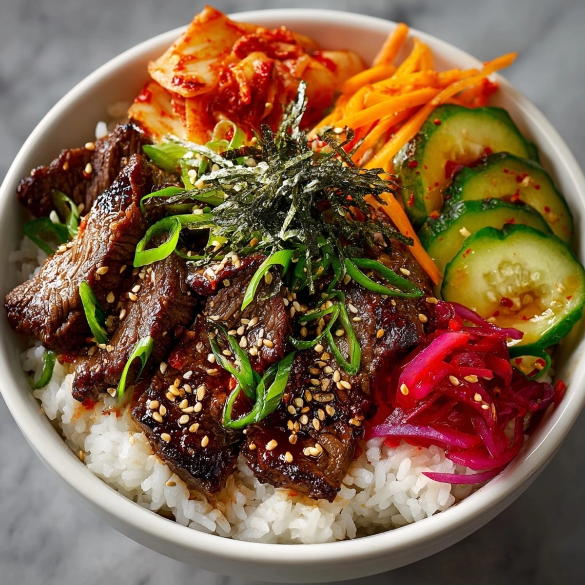Korean BBQ Beef Bowl with Pickled Vegetables arranged over fluffy steamed rice, ready to serve.