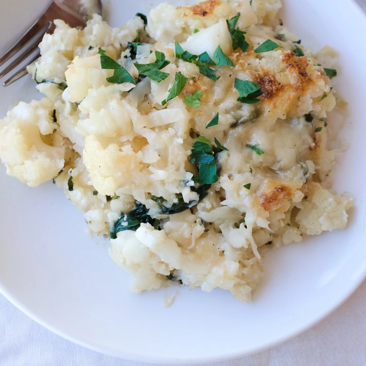 Golden brown Alfredo Cauliflower Rice Casserole bubbling hot from the oven, savory and inviting.