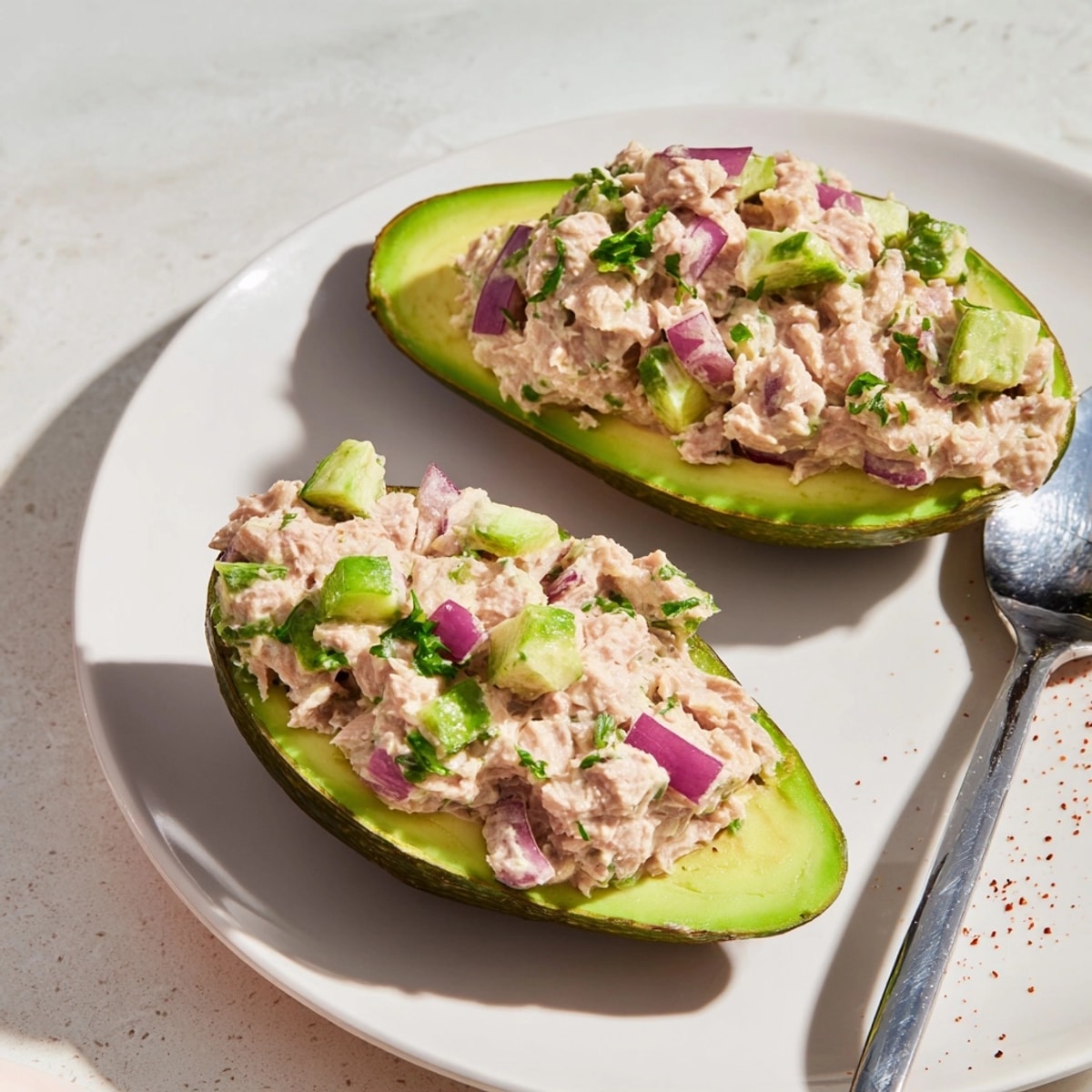 Creamy Avocado Tuna Salad Boats: Tender tuna mix nestled in smooth, ripe avocado halves.