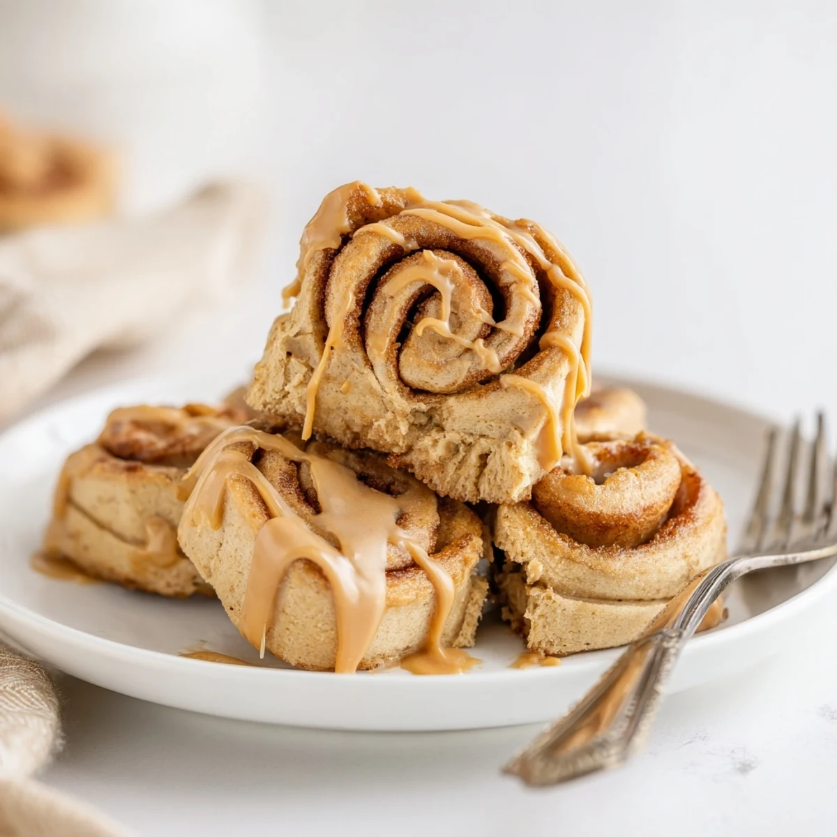 Soft Peanut Butter Cinnamon Roll Cookies drizzled with sweet icing on a cooling rack.  