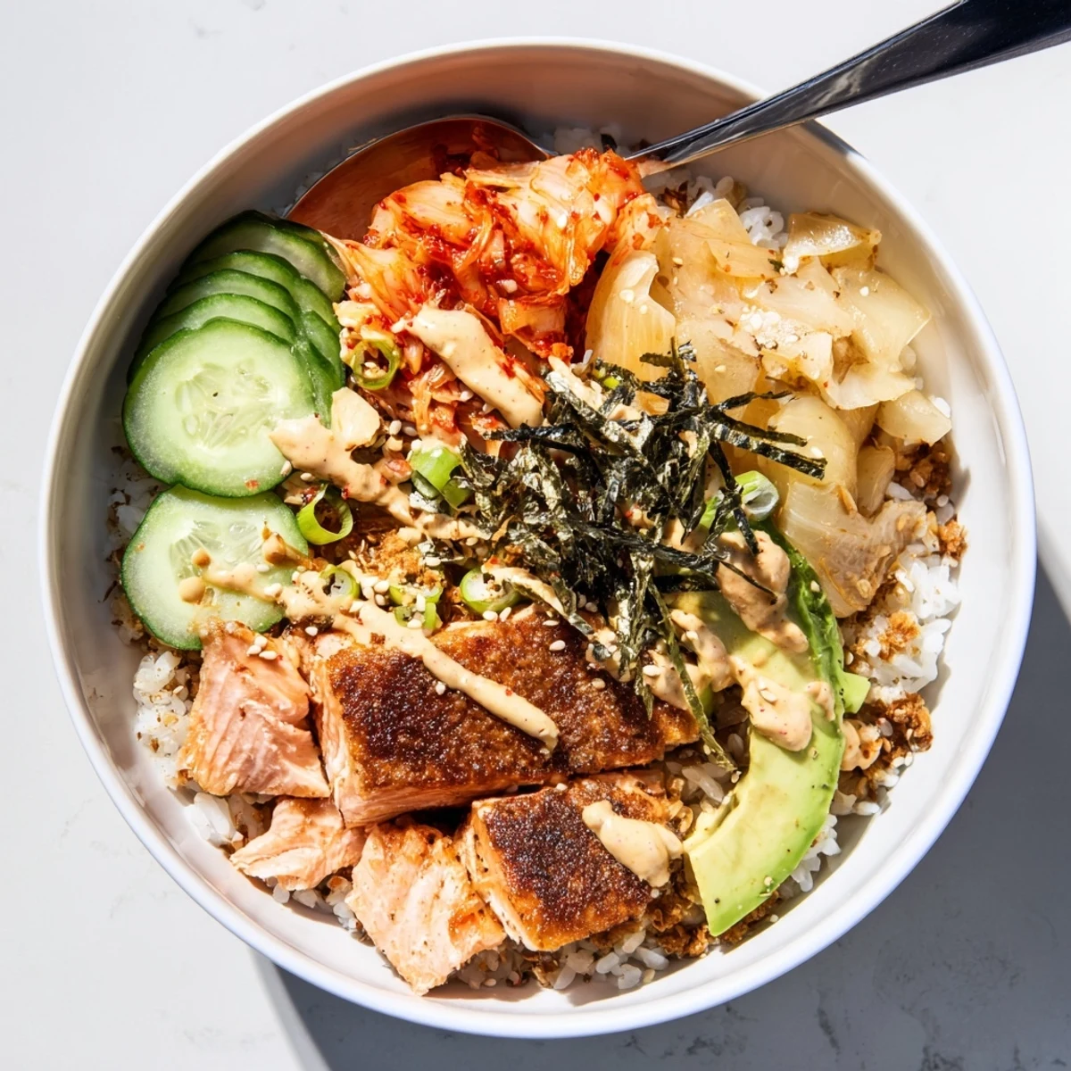 Flavorful Crispy Salmon Rice Bowl featuring crunchy garlic, tangy kimchi, and creamy avocado.