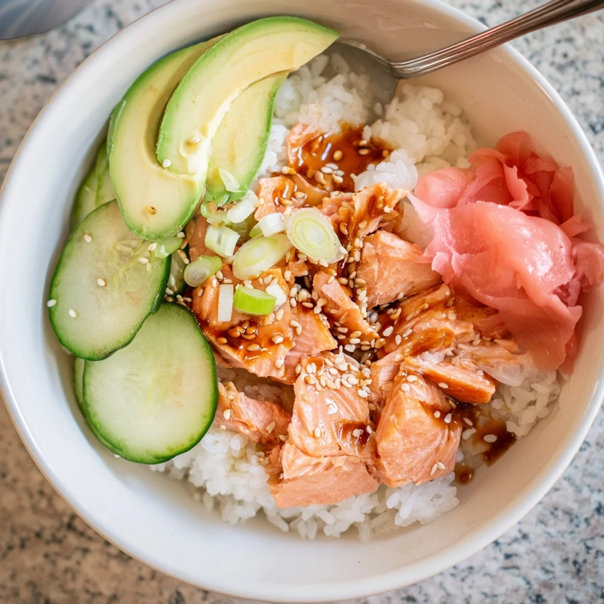 Flavorful Leftover Salmon & Rice Bowl, drizzled with soy sauce and sesame oil.