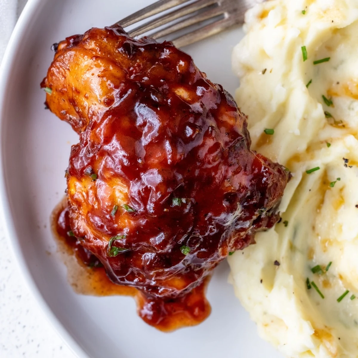 Succulent Honey BBQ chicken thighs glistening with sticky sauce, served with creamy garlic mashed potatoes.  