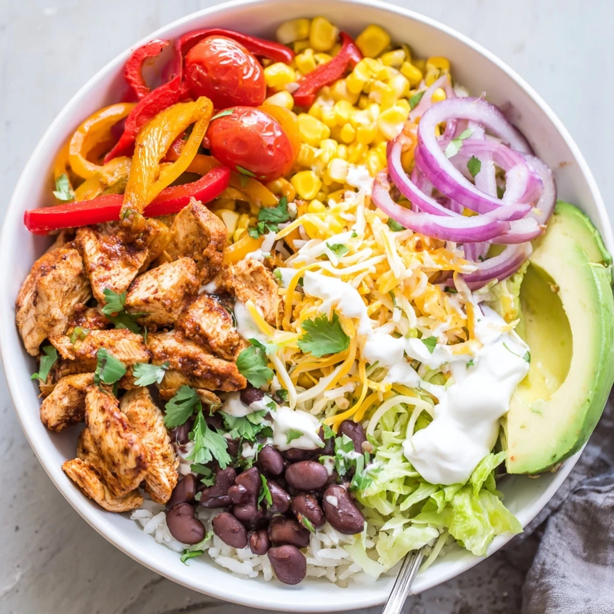 Juicy Sheet Pan Chicken Burrito Bowls topped with fresh cilantro and lime wedges.  