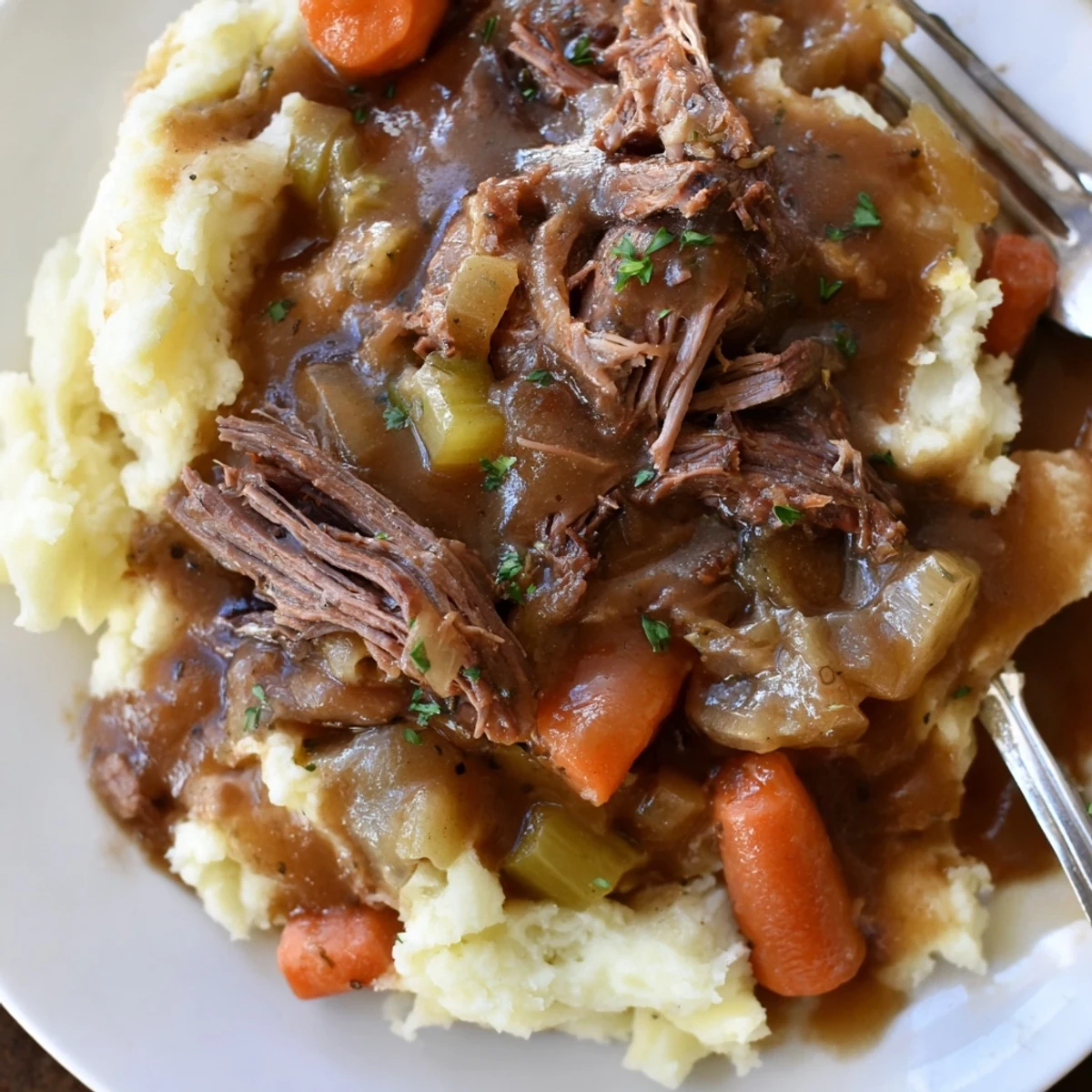 Hearty Slow Cooker Pot Roast with Mashed Potatoes served on a rustic plate.  