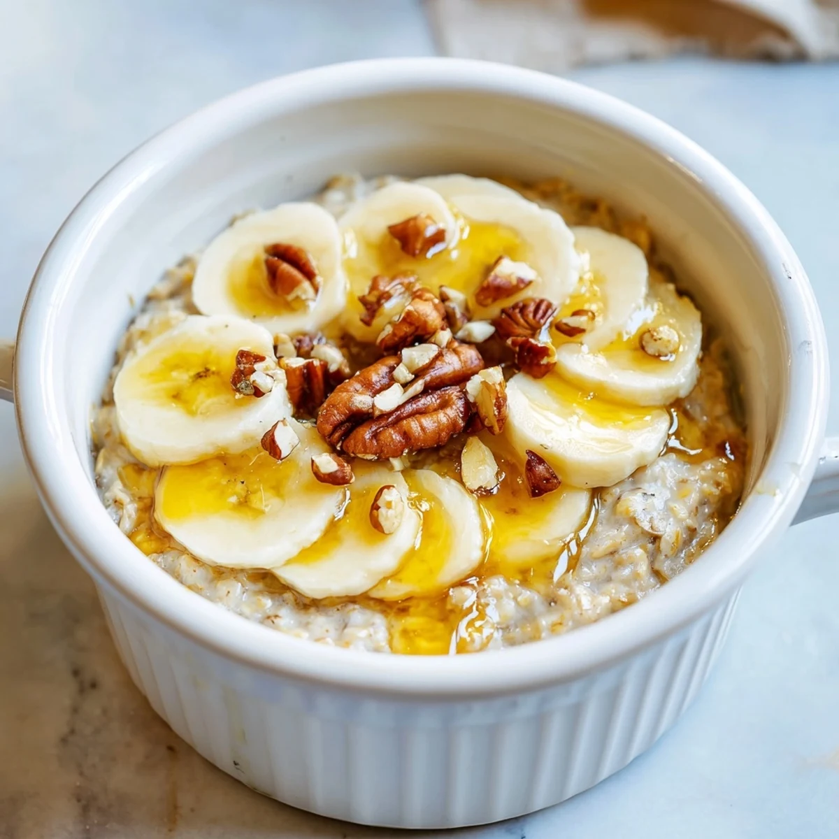 Golden, bubbly baked oats ramekins with a caramelized banana topping, ready to eat.