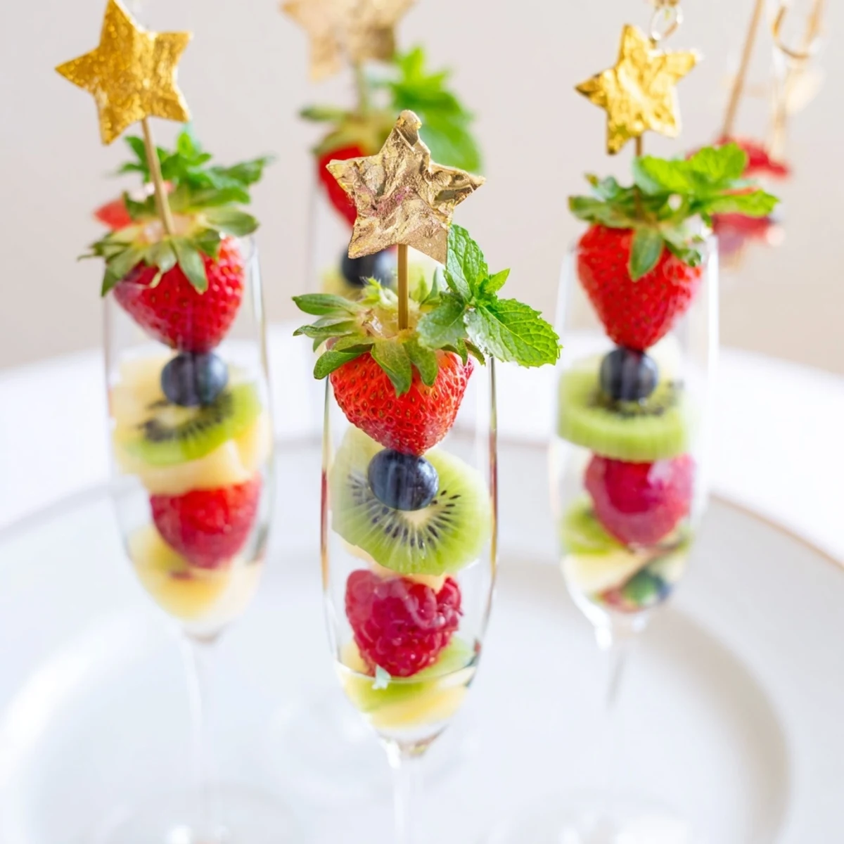 Bright, colorful fruit garnishes over champagne flutes, perfect for a New Year's celebration with vibrant flavors.