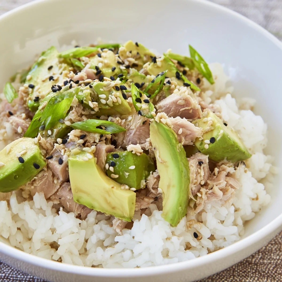 A colorful Tuna Avocado Rice Bowl with creamy avocado, fresh tuna, and sesame seeds.