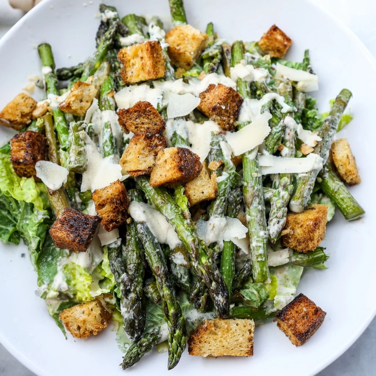 Homemade croutons top this flavorful Roasted Asparagus Caesar Salad, a delightful and healthy meal.