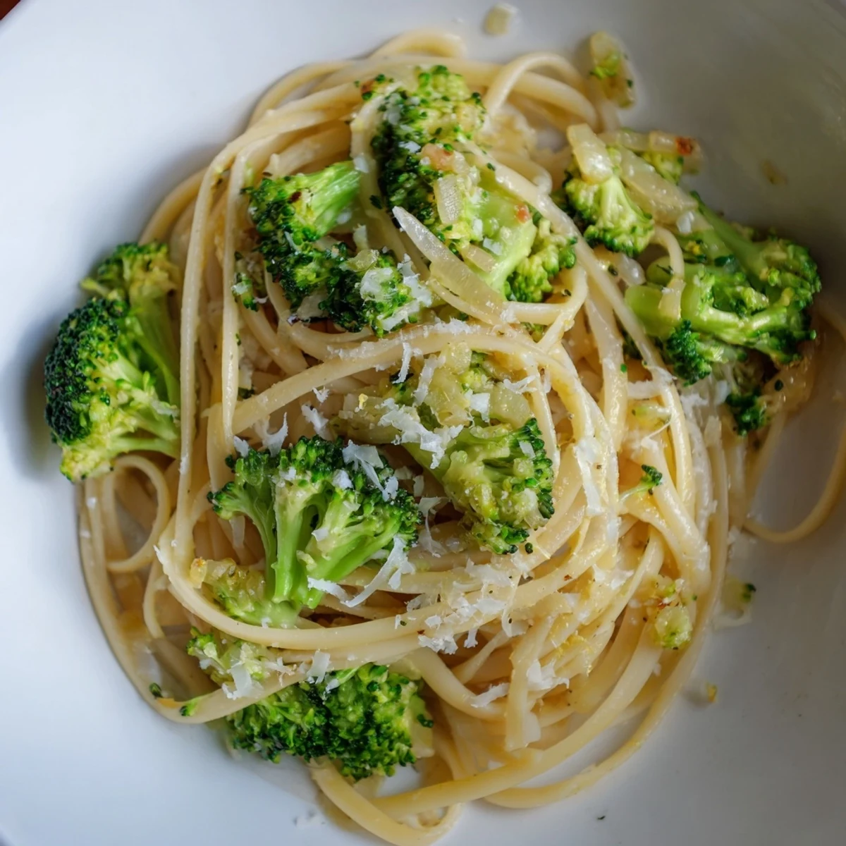 A vibrant photo of creamy One-Pot Lemon Broccoli Pasta, garnished with fresh herbs and Parmesan cheese.
