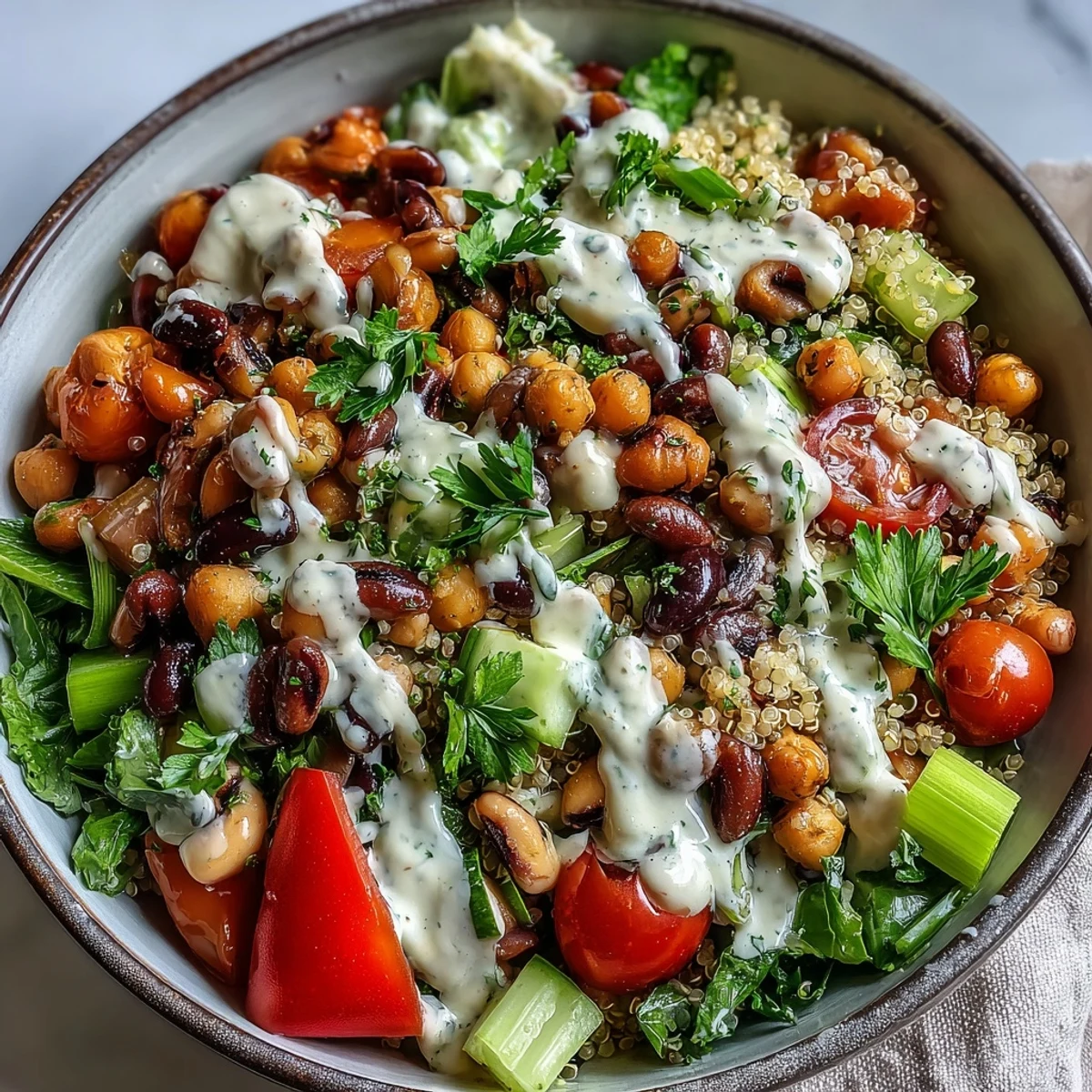 Fresh, chilled New Years Hoppin John Salad features black-eyed peas, chickpeas, and creamy tahini dressing in a vibrant bowl.