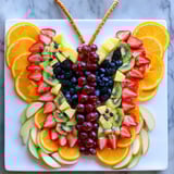 Freshly assembled Monarch Magic Fruit Butterfly Tray, a healthy snack with vibrant orange and red fruits.
