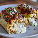 Golden Garlic Butter Lasagna Roll-Ups served on a white plate, paired with a fresh green salad for dinner.
