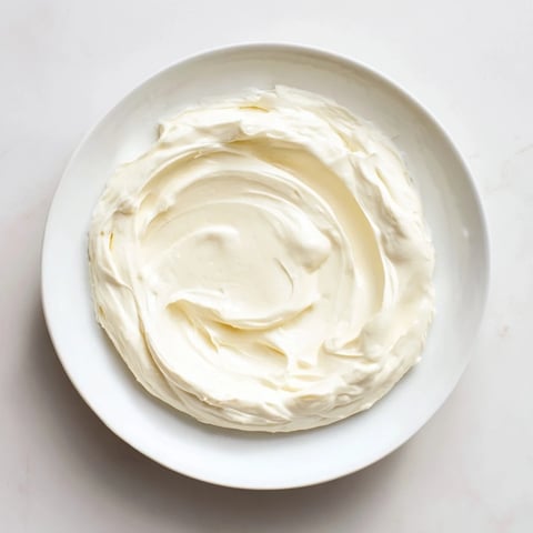 Creamy mascarpone cheese spread atop a rustic bread slice with fresh berries.  