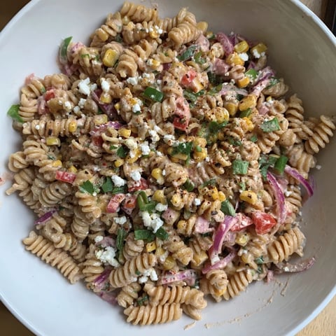 A colorful bowl of Healthier Mexican Street Corn Pasta Salad showcases charred corn and creamy dressing.