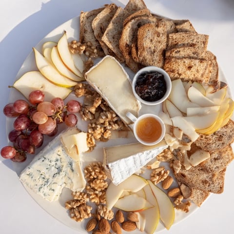 A close-up of a beautifully arranged cheese platter Cœur Passion, overflowing with fresh fruit.