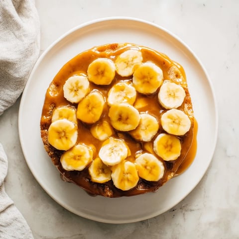 Moist banana bread cake with caramelized bananas, offering a delightful aroma and texture.