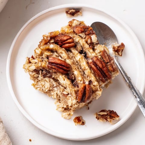 Homemade Cinnamon Swirl Baked Oatmeal, sliced and steaming, topped with fresh berries and yogurt.