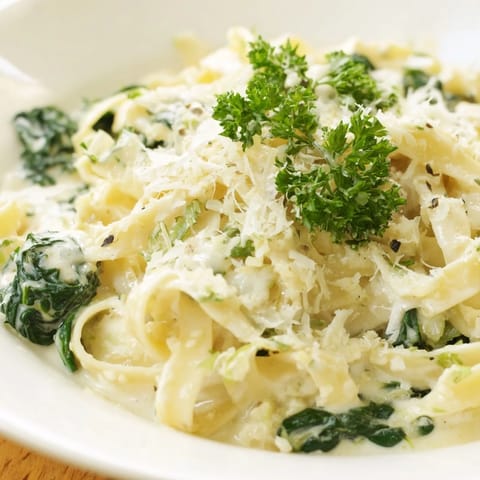 This Creamy Garlic Spinach Pasta features wilted spinach and Parmesan, offering a comforting aroma.