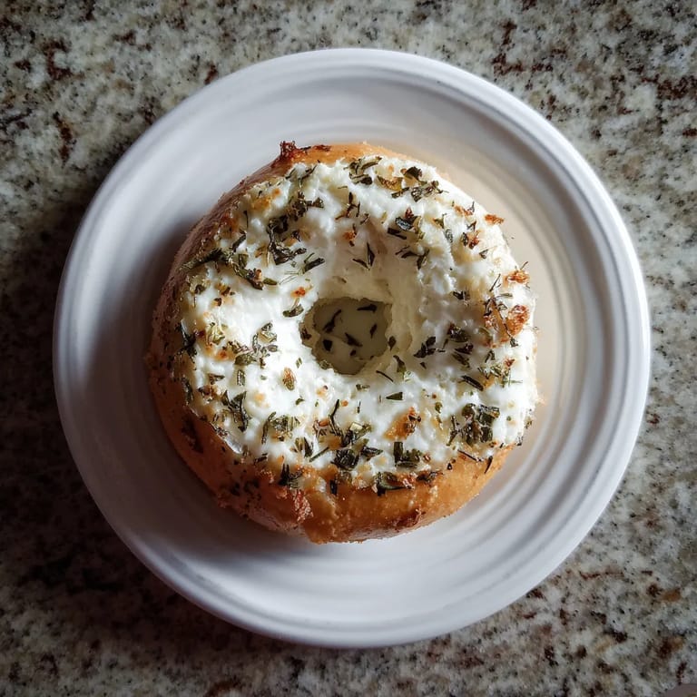 A white plate with a bagel on it.