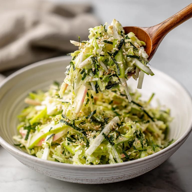 A wooden spoon is used to scoop up shredded cabbage.
