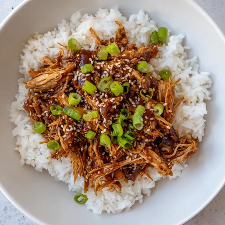 Homemade easy slow cooker teriyaki chicken with rice, glistening sauce over chicken and grains; a flavorful meal.