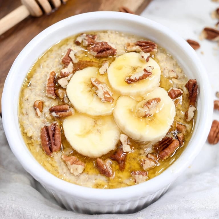 Individual baked oats ramekins with a honey drizzle and sliced bananas, perfectly cooked breakfast.