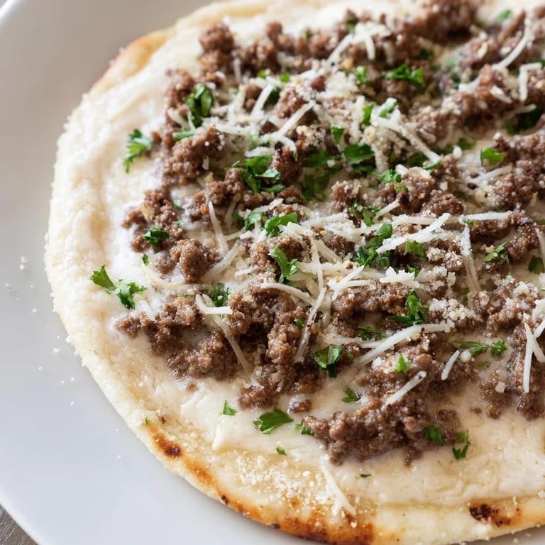 Delicious Ground Beef Alfredo Pizza, fresh from the oven, featuring a bubbling mozzarella and Parmesan topping.