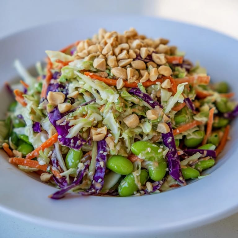 Vibrant Crunchy Thai Peanut Salad with shredded carrots and cabbage, drizzled in a flavorful peanut sauce.