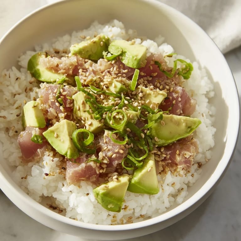 Savory Tuna Avocado Rice Bowl with sesame seeds, a quick lunch bursting with fresh flavors.