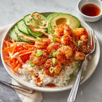 A plate of food with shrimp, rice, and vegetables.