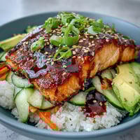 Delicious teriyaki salmon bowl with tender glazed salmon, crisp vegetables, and steamed jasmine rice.  